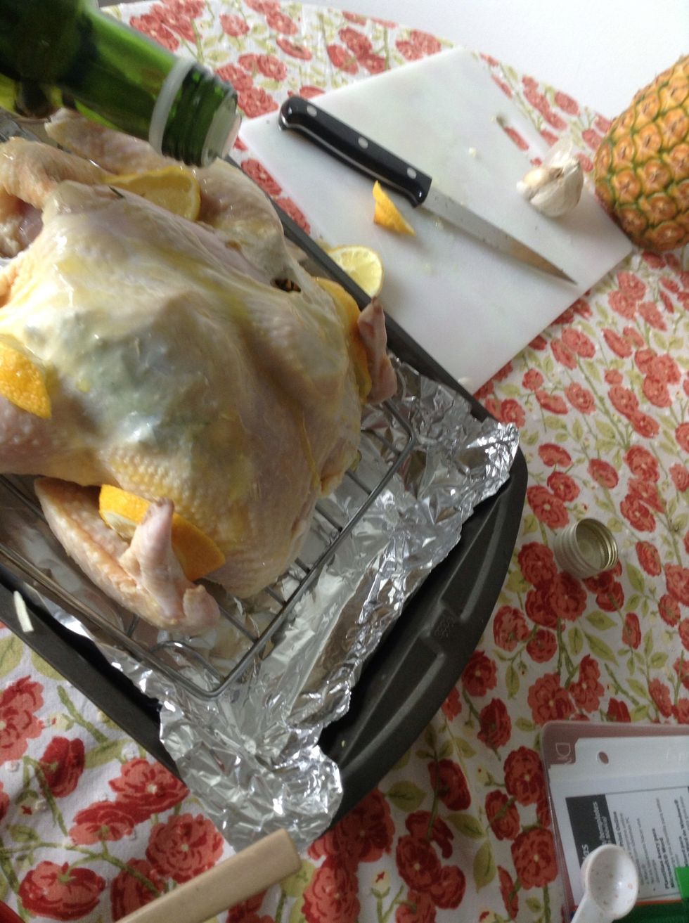 Slice the second lemon into quarter slices and place those around on the outside of the chicken. Drizzle olive oil over the skin of the chicken and rub in to make sure it's completely covered.