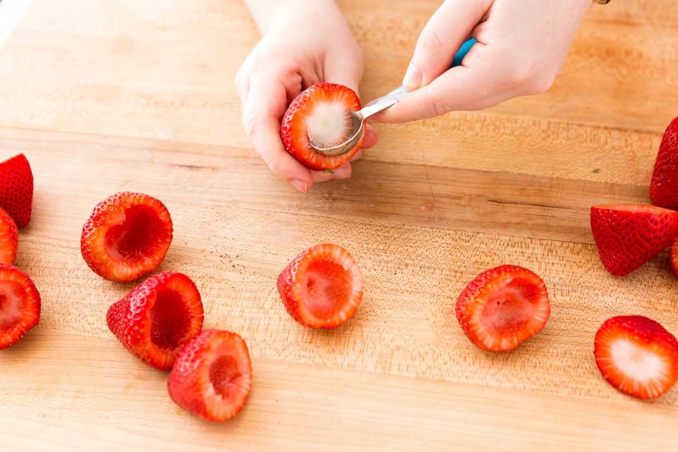 Slice the stems off your strawberries and scoop out the centers with a small melon baller. Dry off your berries with a paper towel.
