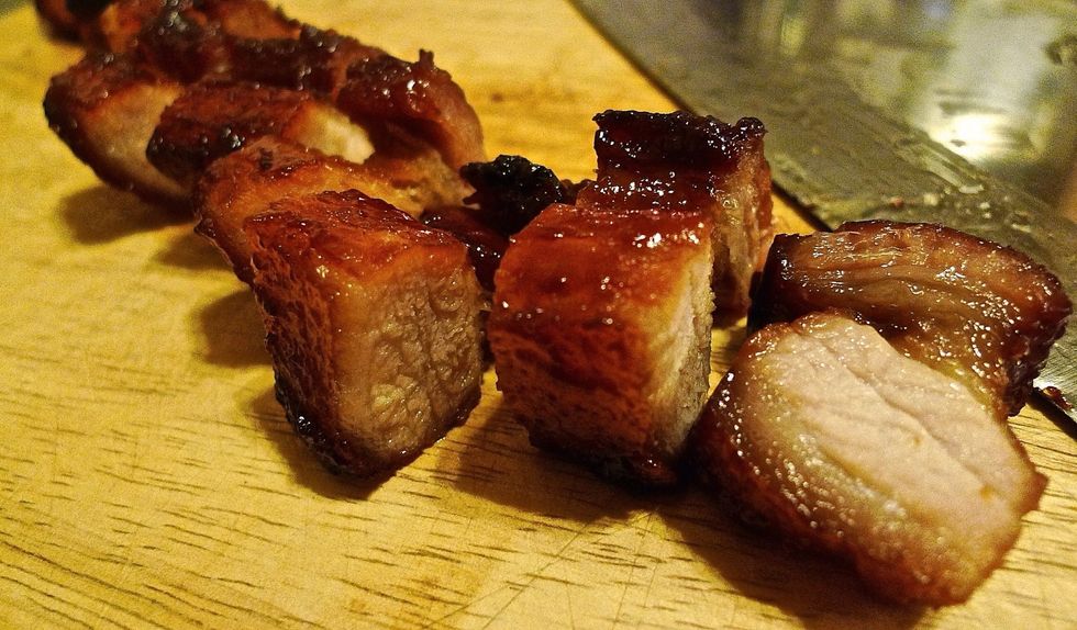 Slice the tender and juicy grilled barbecue pork on a chopping board.