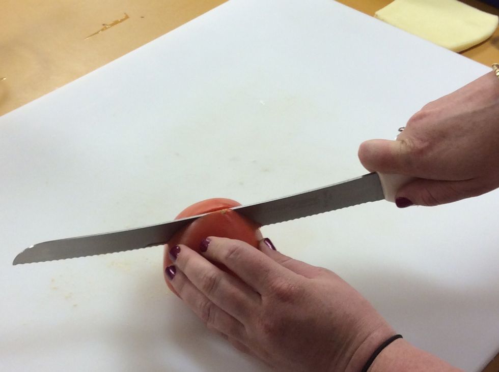 Slice the tomato in half using a serrated knife.
