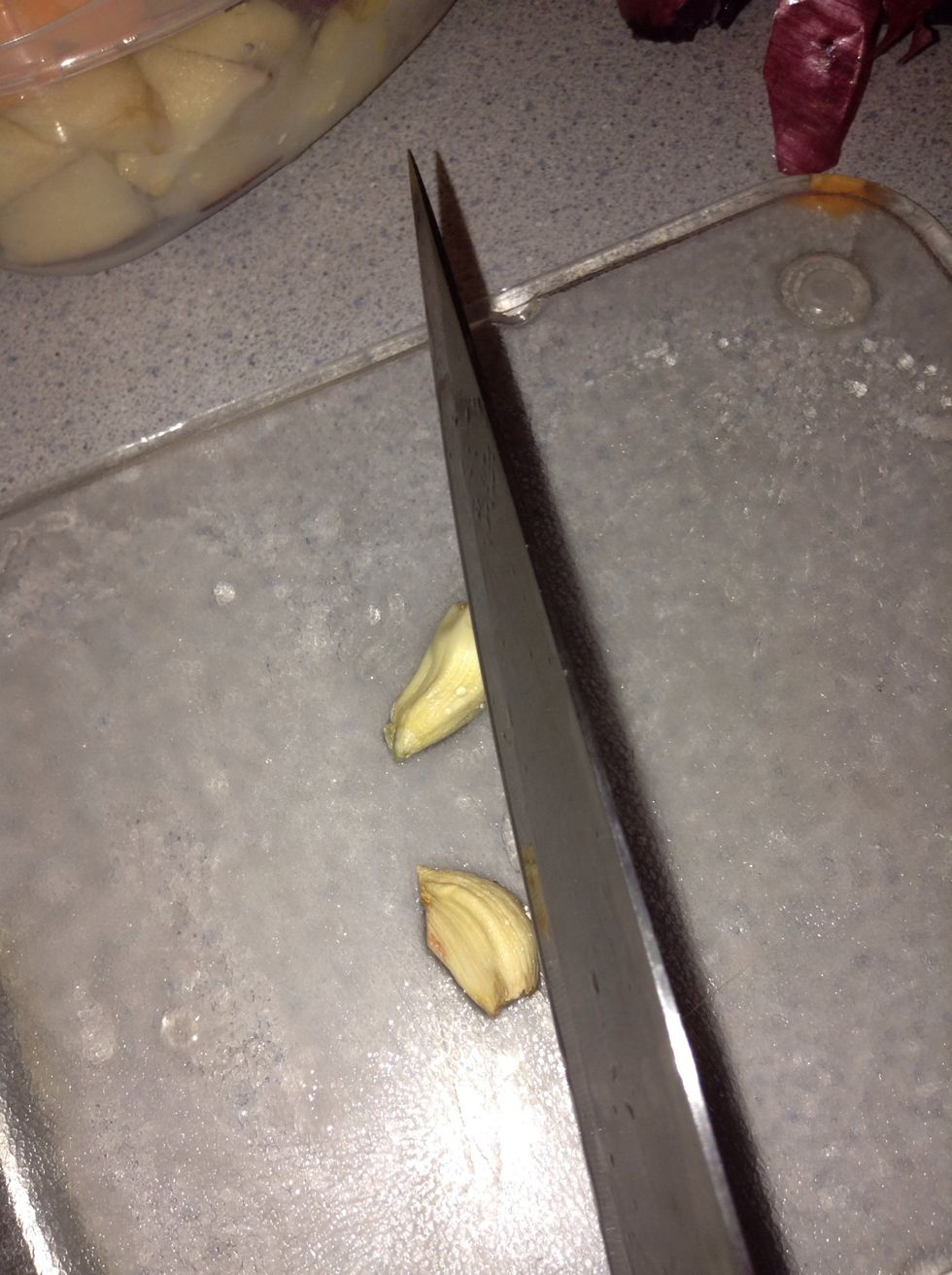Slice up garlic and chop finely. Put on same plate as onion and set aside.