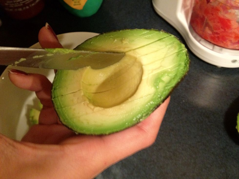 Slice up the avocados and then spoon them out into a bowl