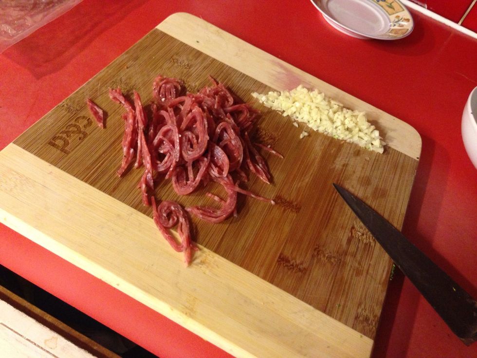 Slice up the salami into little strips, along with the onion and garlic. Heat up a pan and melt the butter. Stab each sausage once in the middle, fry over a medium heat, turning frequently with tongs.