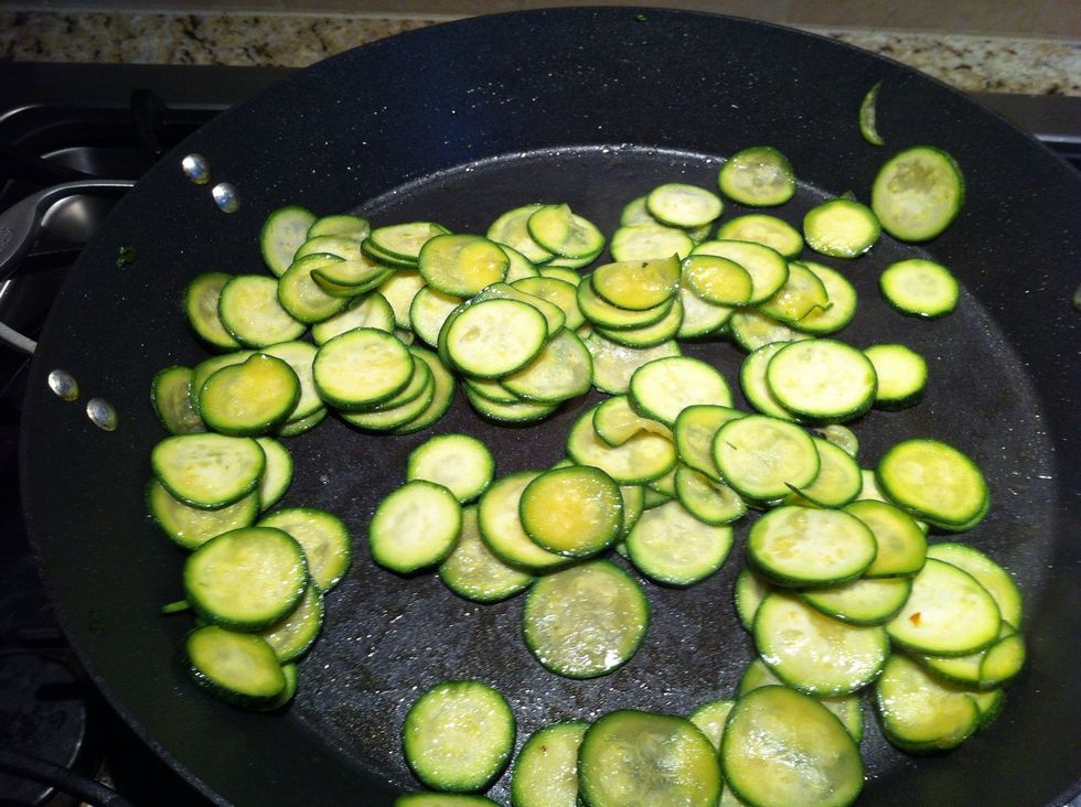 Slice zucchini into thin rounds and saut\u00e9 in olive oil and sesame oil for taste. Add a dash of S/P. I like to cook into it until it is translucent and curling up.