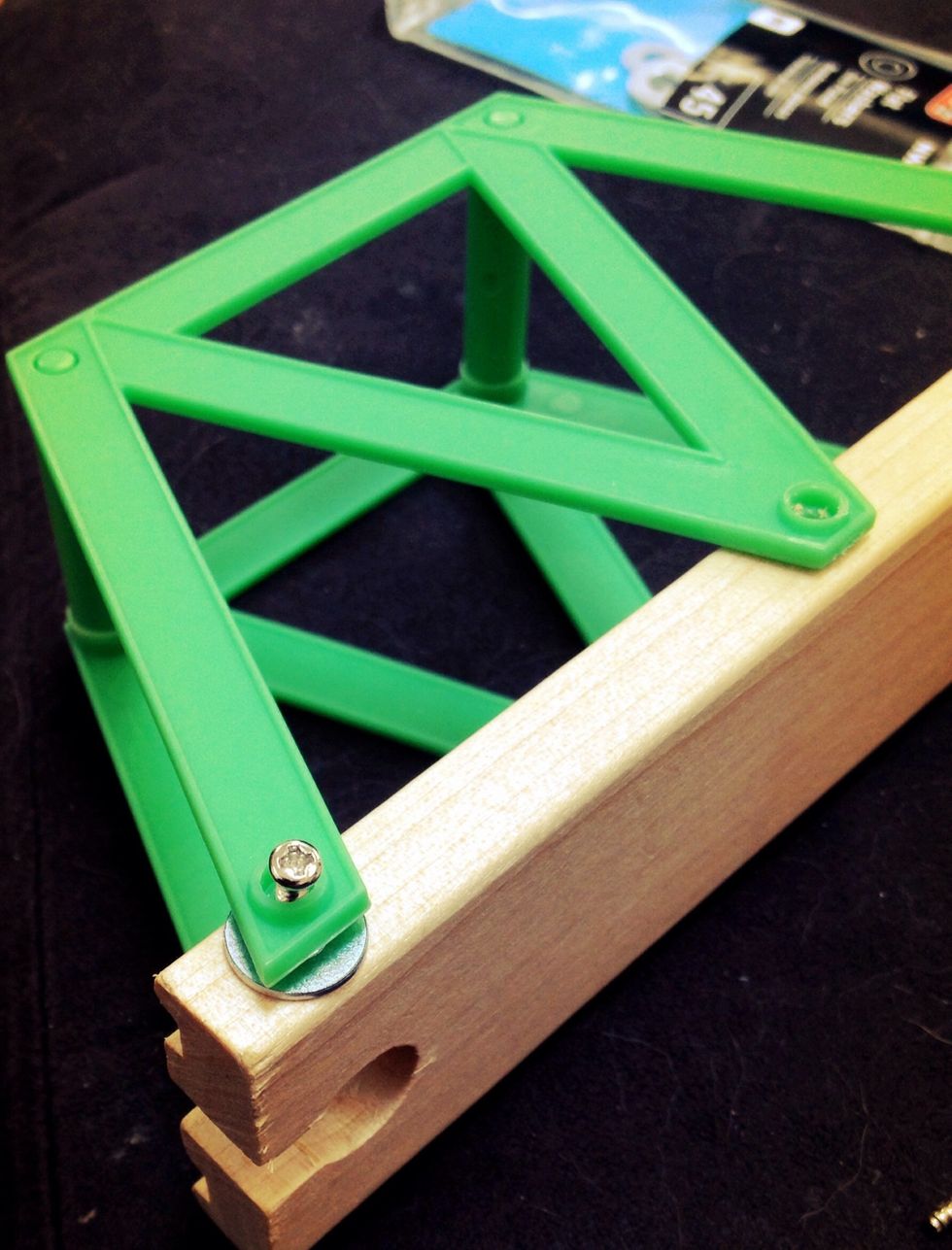 Slide 1-2 flat washers between the screws and the track piece, then tighten the screw back in. Repeat for all screws connecting to the track piece.