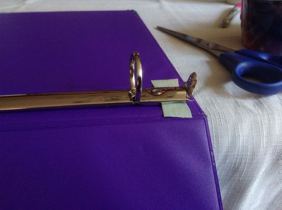 Slide a bit of tape under the end of the ring mechanism.