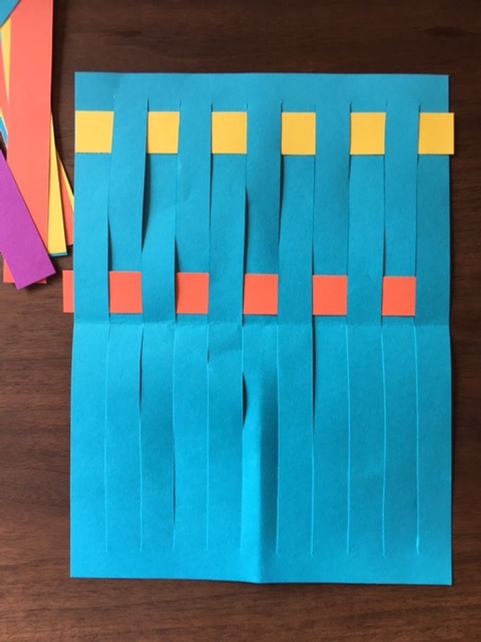 Slide first weft line to top of loom. Choose a different color weft line. Change pattern for weaving to BABA. Weave this weft line through warp lines.