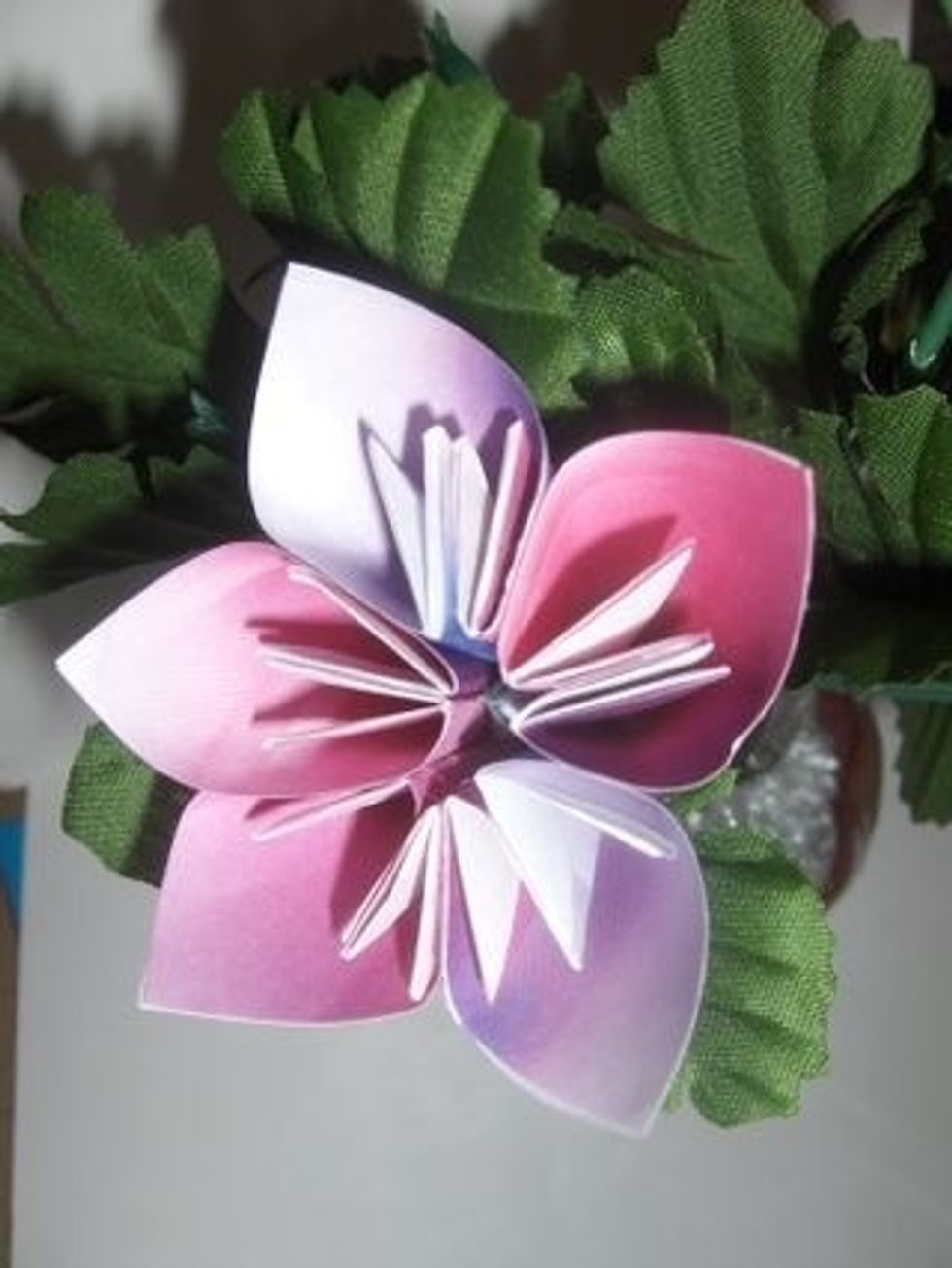 Slide flower onto stem- there is a natural opening at the base of this type of origami flower.