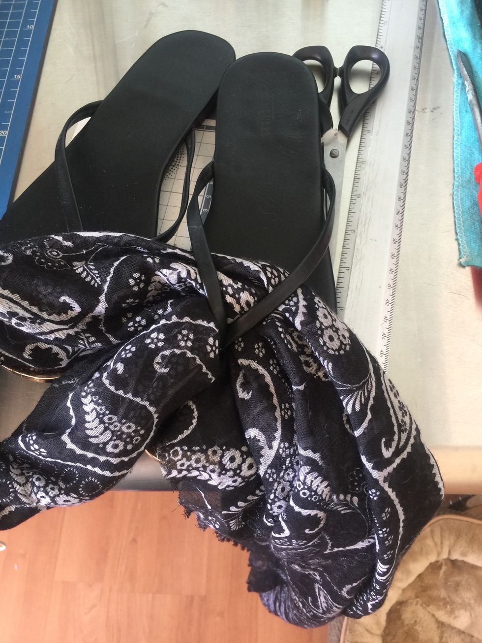 Slide in half the scarf through the sandals to make a knot in half