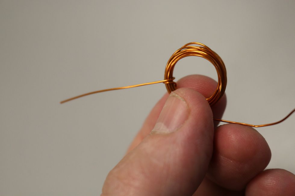 Slide it off the battery and then pull one end through the coil and wrap it around once to hold that end in place.