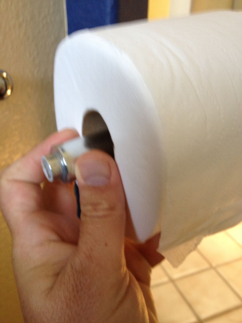 Slide new toilette paper roll in spring loaded spindle.