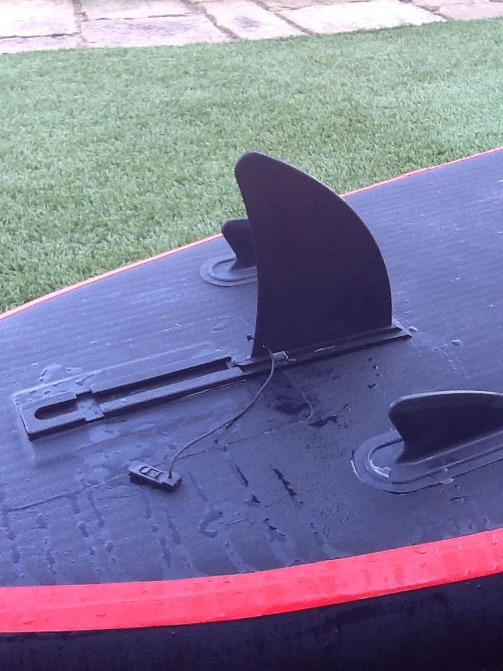 Slide & Snap - Step 1 - clear all sand and grit. It doesn't matter if the board is inflated or not. Begin sliding the fin backward, pushing on the bottom of the fin (not the tip).