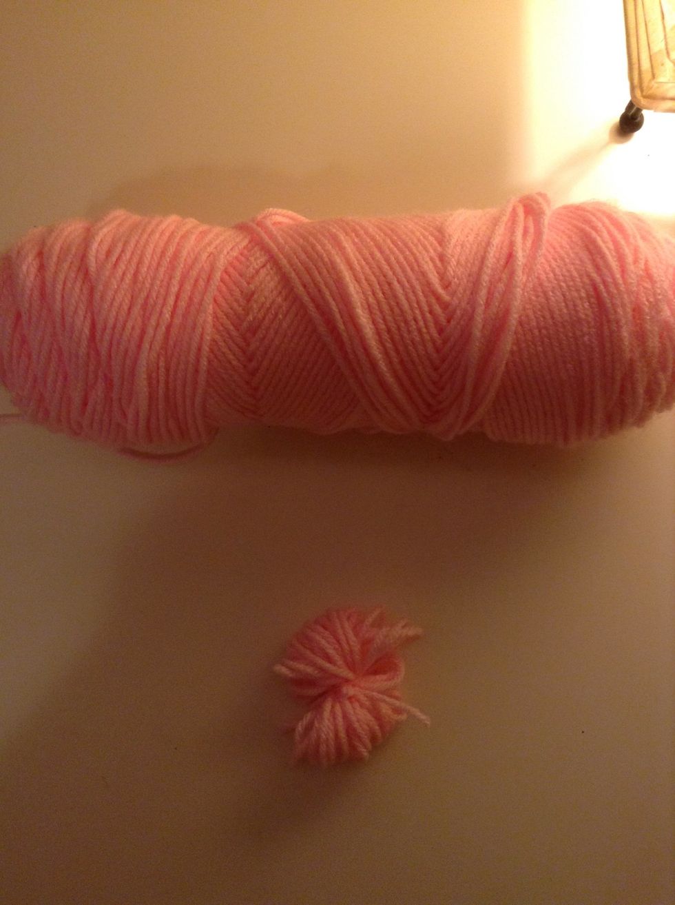 Slide that yarn off your fingers and wrap the piece you cut around it as shown