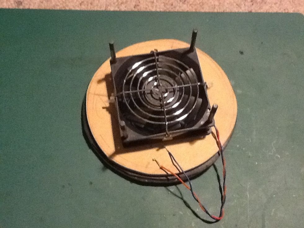 Slide the fan over and down onto the four bolts with the first fan guard facing up. Your fan should be pushing air through the rings ( in the above image that would be down)