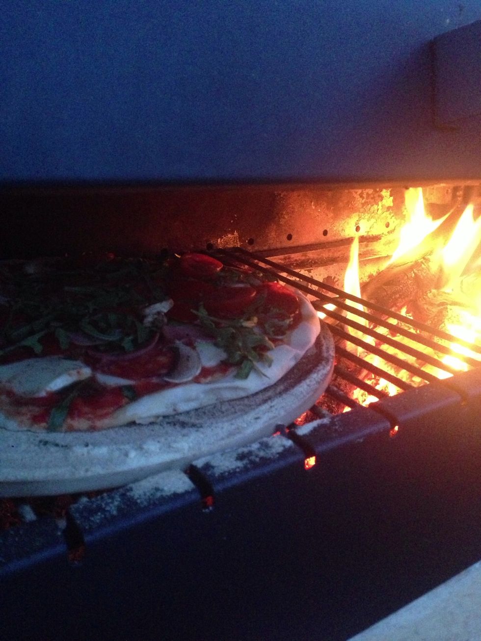Slide the pizza onto your stone, crack open a beer and watch that baby cook. It'll take about 15-20 mins.