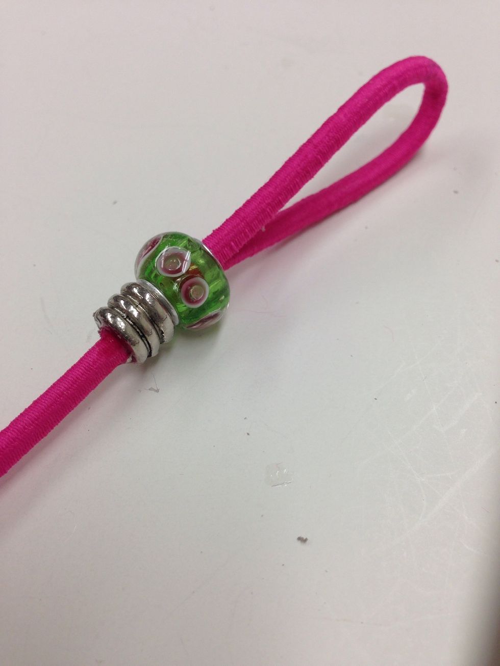 Slide the second bead into place under the first bead. Don't worry about gluing this bead. Friction will keep it in place. Repeat steps 24-28 for the second piece of bungee cord.