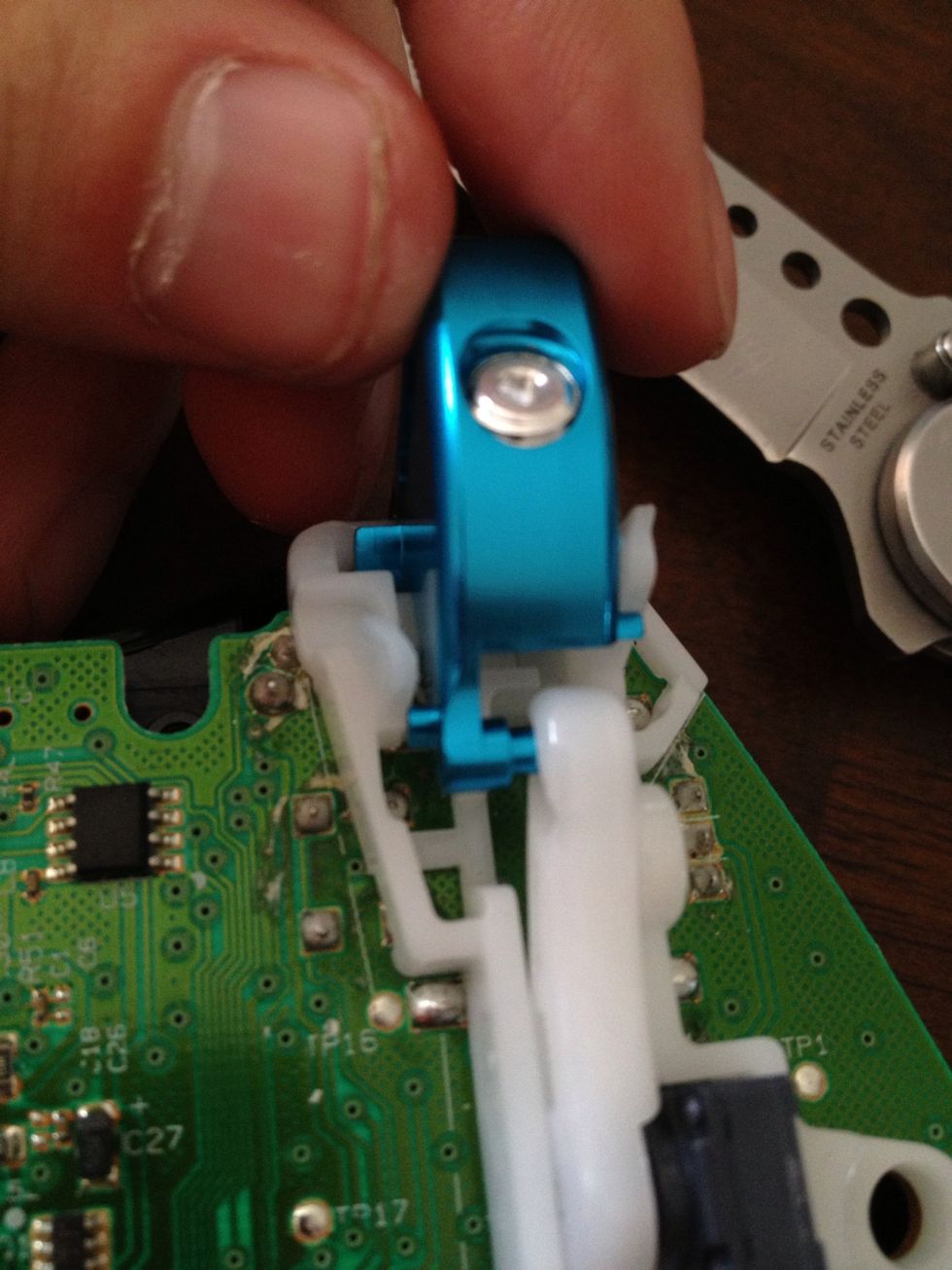 Slide the triggers in starting at the top. You may have to use something thin to assist you in getting the peg set back into the white plastic arm. It takes a bit of concentration.
