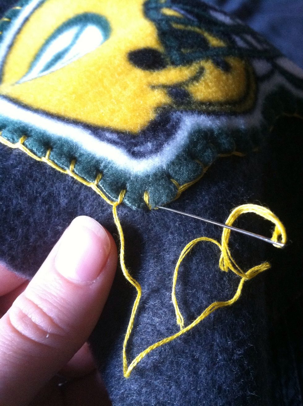 Slide your needle around the far side of your first stitch and put it down through the base fabric.
