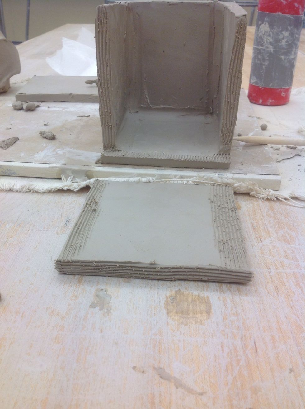 Slip and score another "A" piece on the edge and two sides. Slip and score the place where it will attach on the box.