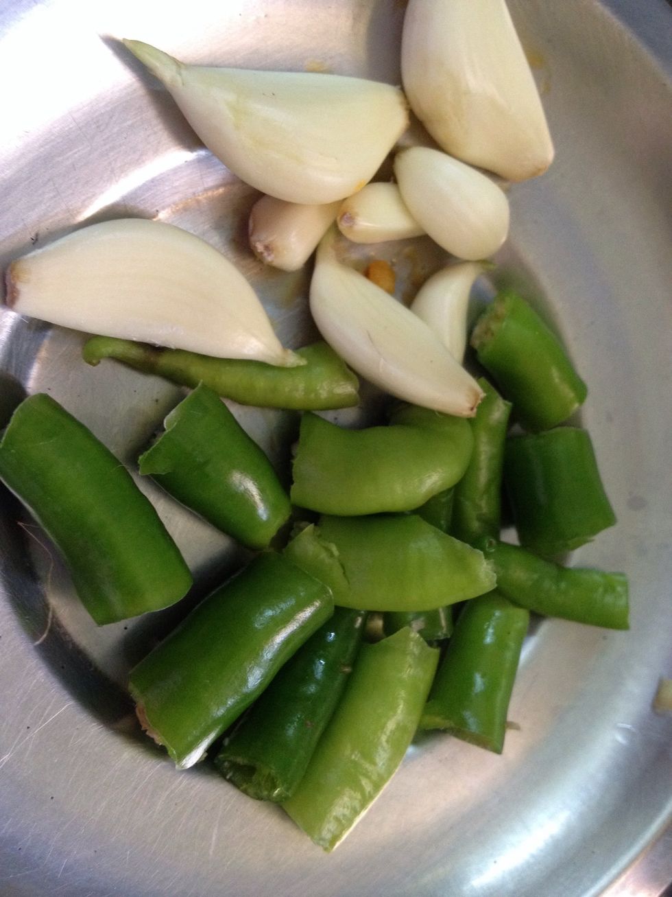 Slit the chillies and garlic cloves aside