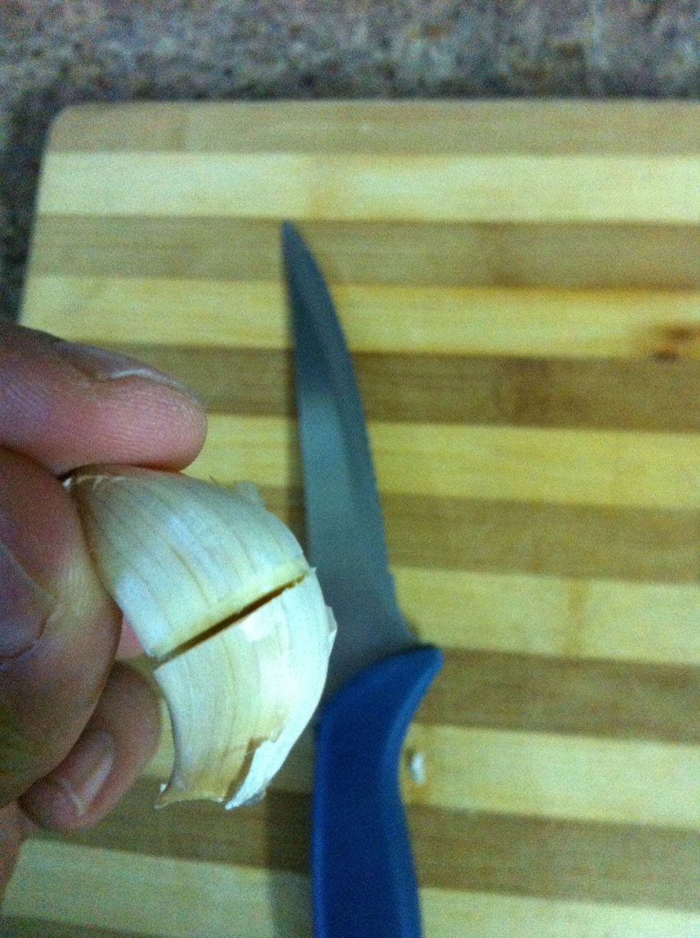 Slit the cloves of garlic with a knife. Do not cut it all the way through! Also, don't remove the skin from the garlic or else it will burn and get bitter!