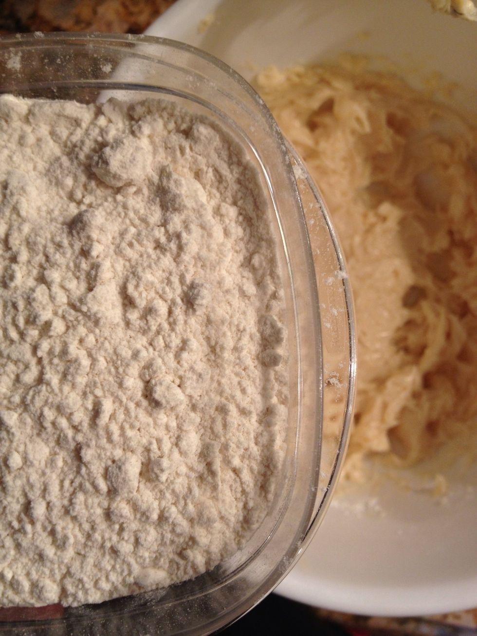 Slowly add in the flour. At first it will seem dry, but the dough will come together eventually.