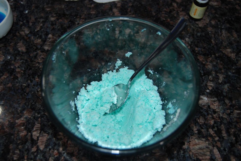 Slowly keep adding more of the wet ingredients until the mixture is barely clumped together and the consistency is that of damp sand and the color you want your bath bomb to be