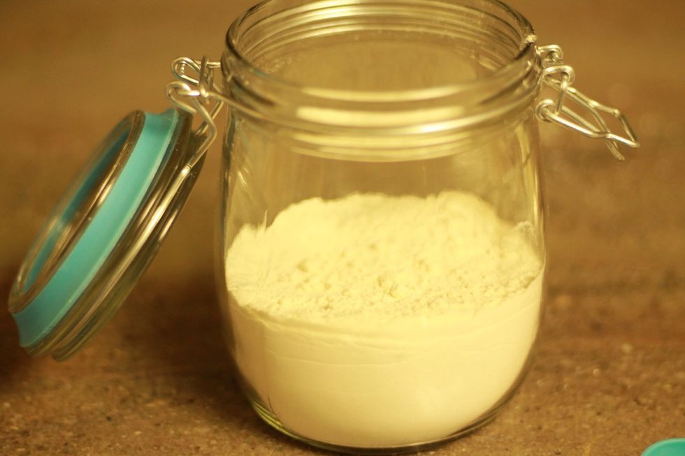 Slowly pour in the flour. Tap the jar on the counter lightly to get things even.