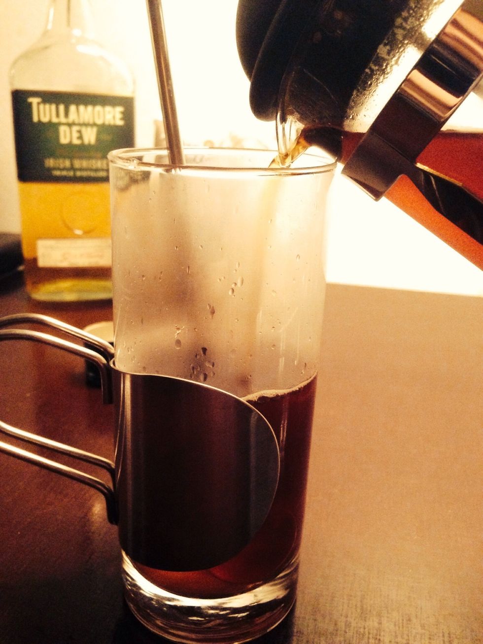 Slowly pour in your freshly brewed coffee. Leave a metal spoon in the glass to prevent it from cracking from the sudden change in temperature.