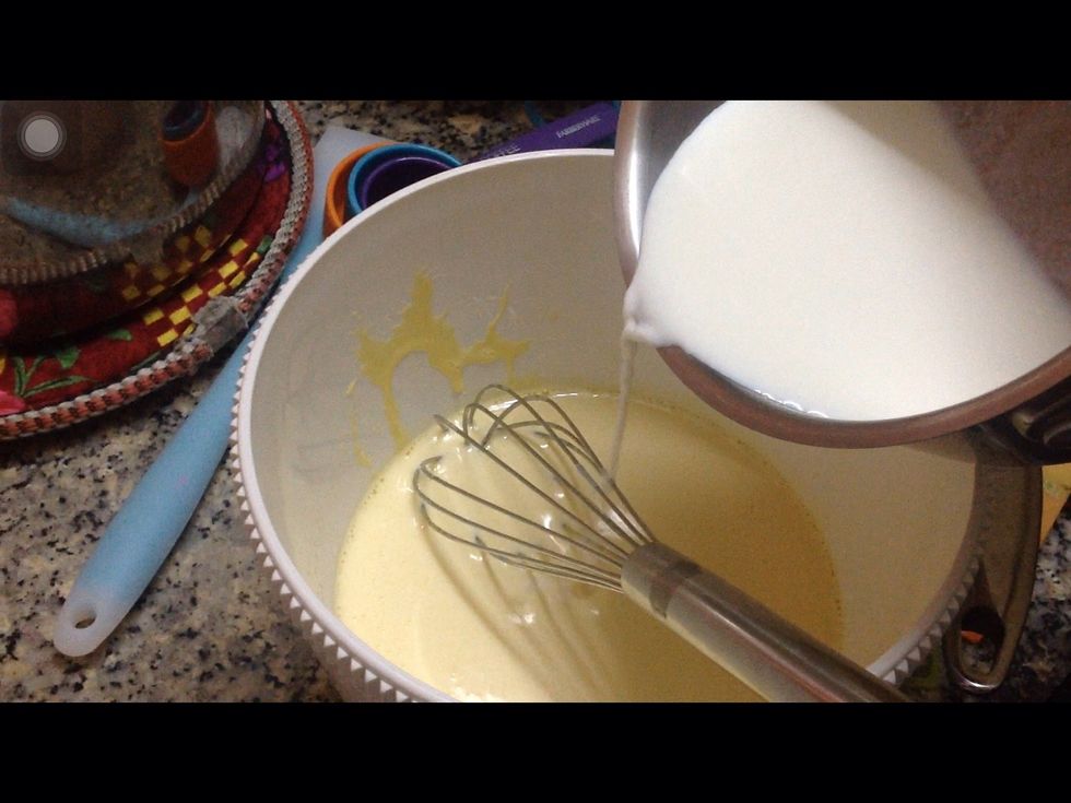 Slowly pour the warm milk to the egg mixture. You have to be careful, pour a little bit and whisk it and slowly pour another bit in and whisk. It will help avoid the cooked egg clumps.