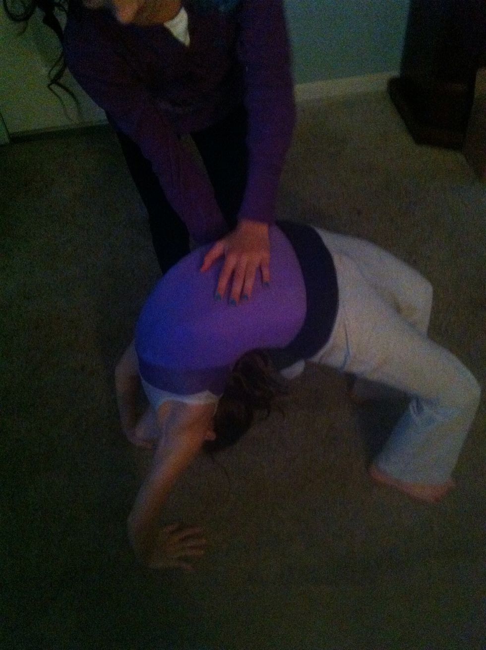 Slowly start to go backwards. The 'spotter' should support you as you do this.