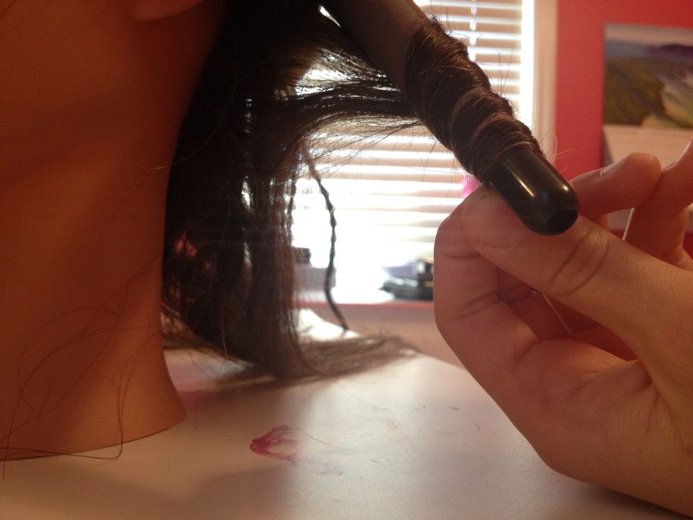 Slowly wrap the piece of hair around the curling iron and hold it for 10 seconds