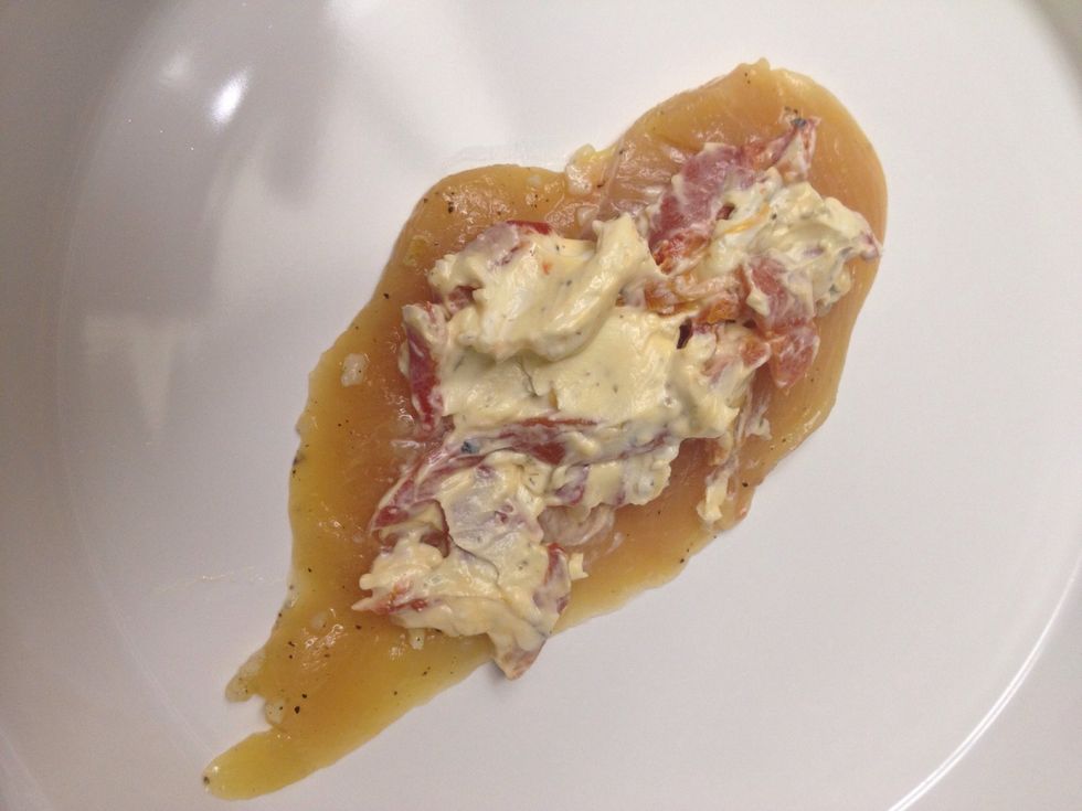 Smear goat cheese filling onto chicken.