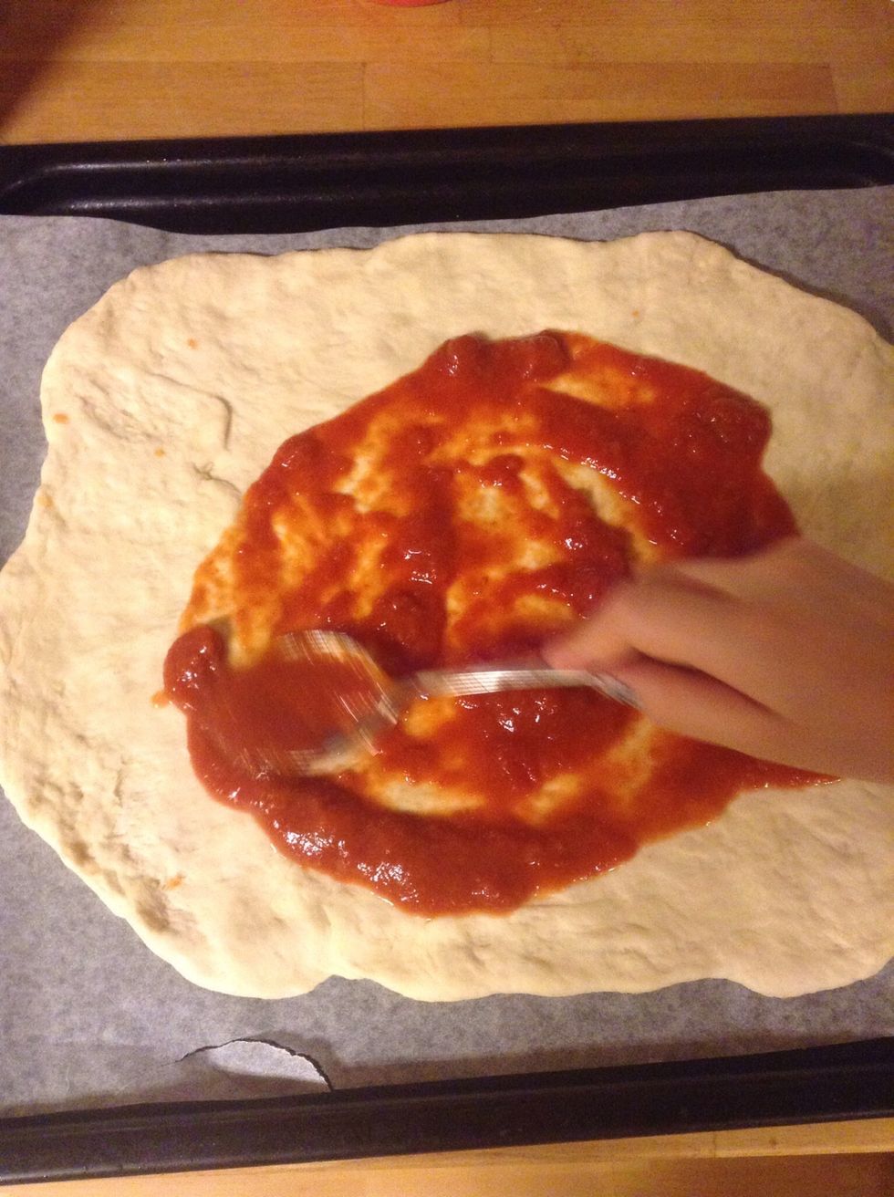 Smeta ut krossade tomaterna. Spread the cross tomatoes on your pizza.