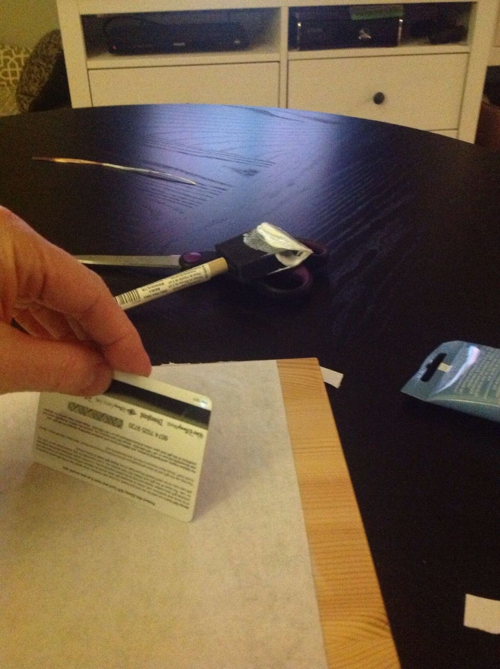 Smooth out the bubbles using a credit card, or something with a flat edge.