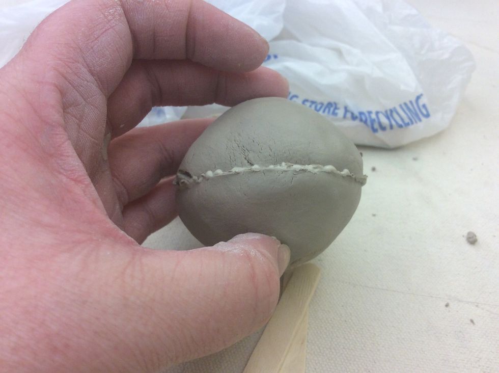 Smooth the two pinch pots together and seal the seam so air can not escape.