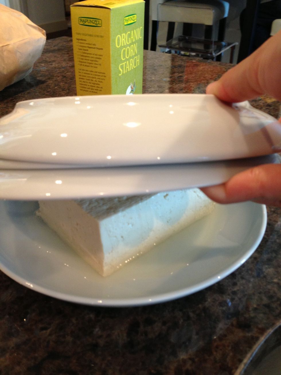 Smush firm tofu under some plates to get rid of excess water. Wait 15 min and drain water.