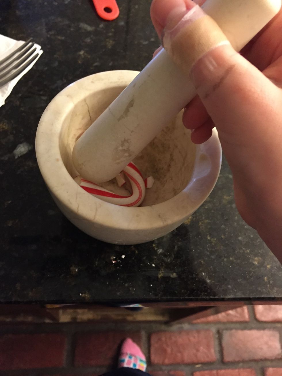Snap the candy cane in half and put the curved half into the crusher