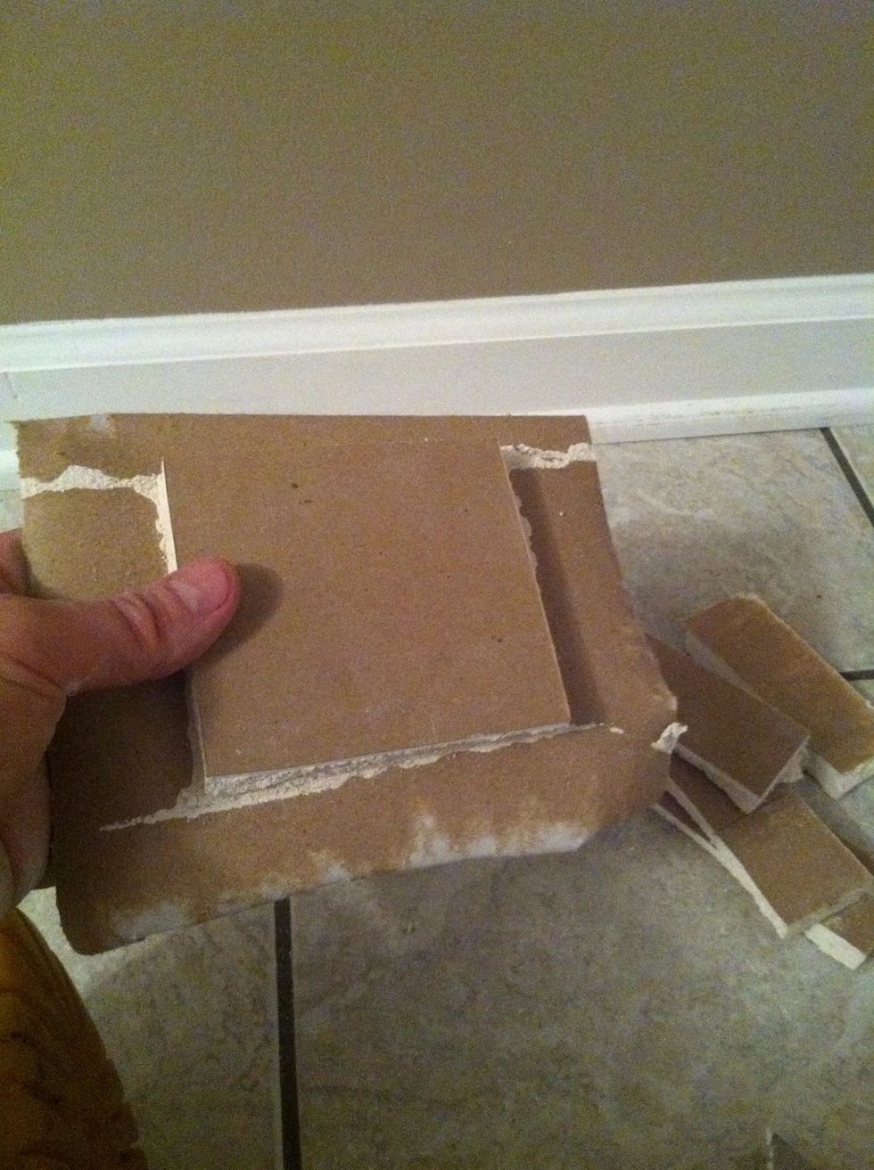 Snap the edges off of the repair piece and leave the paper on the front. Make sure to clean off any remaining drywall from the paper.