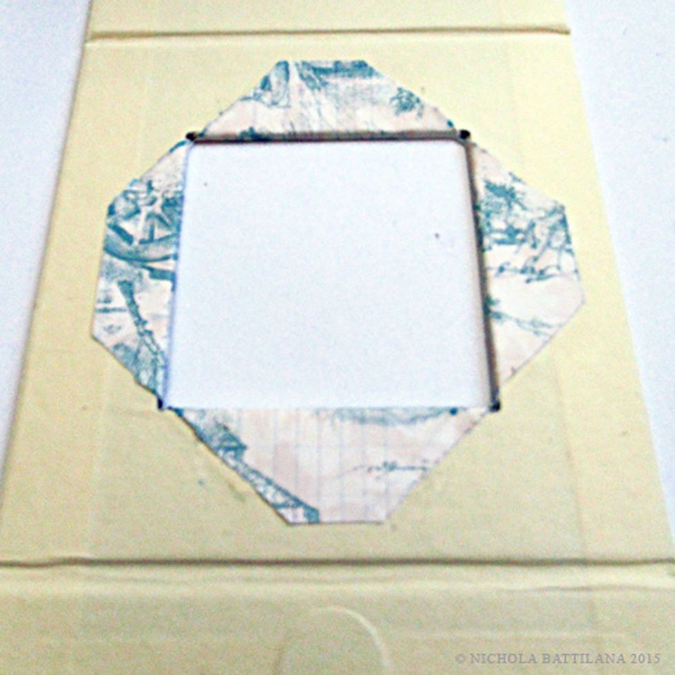 Snip the top corner off, then fold through the window and glue to the inside of the box.