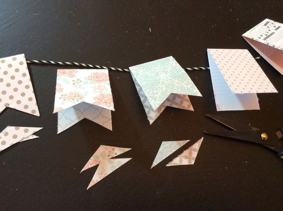 Snip triangular shapes from each folded piece creating pennant shapes.