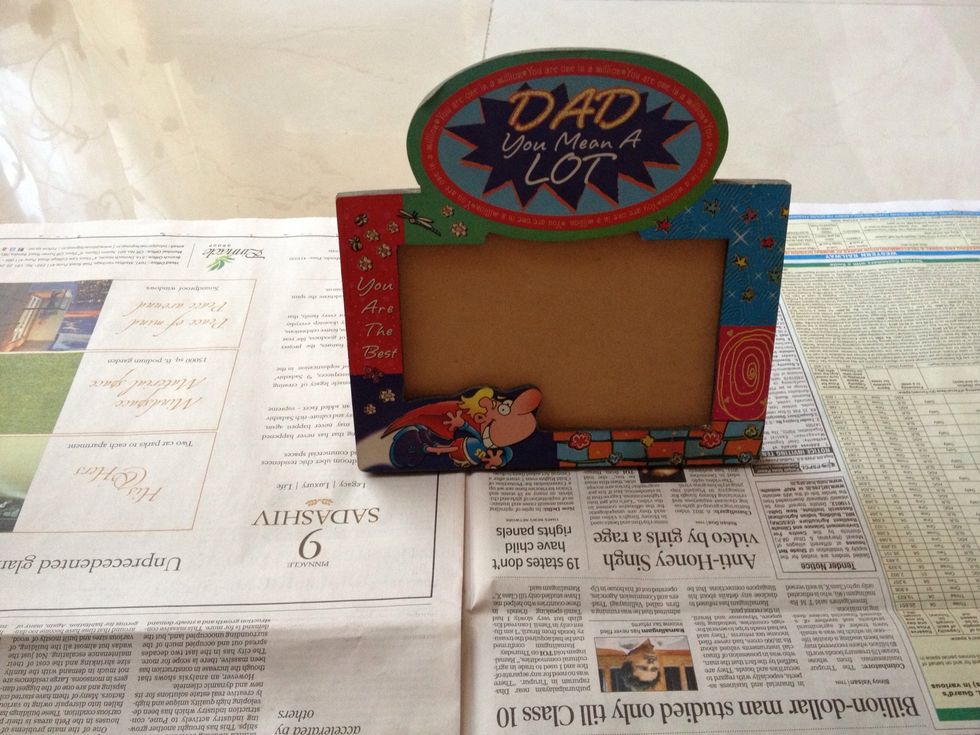 So begin using your old photo frame you wanna give a makeover to. Always use a newspaper underneath to avoid things getting messy. The last thing you want is a messy workplace.