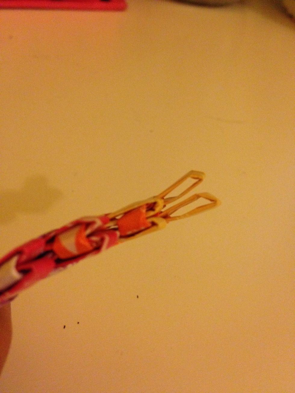 So here I have started a bracelet and all you have to do is take a folded piece and stick it through. Make sure you have the opening side down. (Down would be toward the rest of your bracelet).