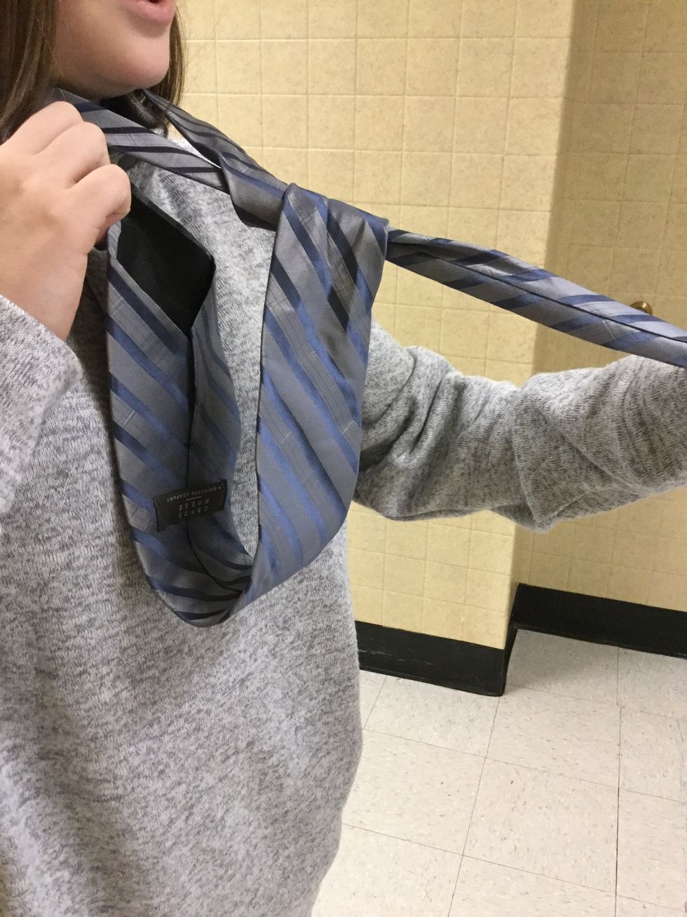 So it gets a little tricky now. You bring the fat side up through the part around your neck. Make sure you don't twist the fat side.