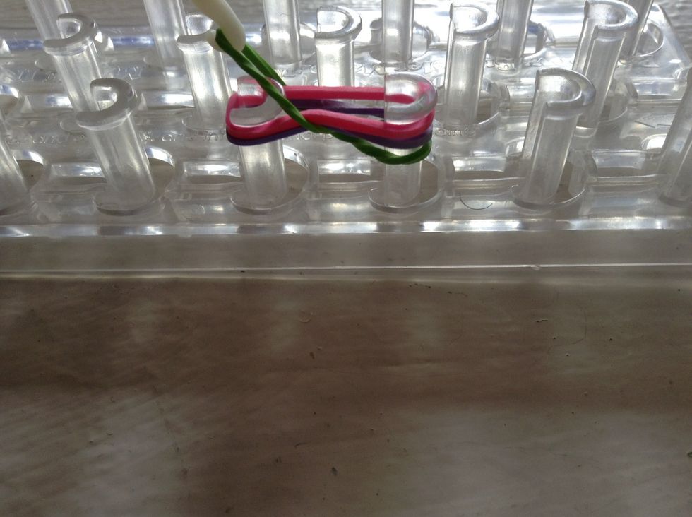 So, now you take your pin and pull the bottom left rubber-band up and over.