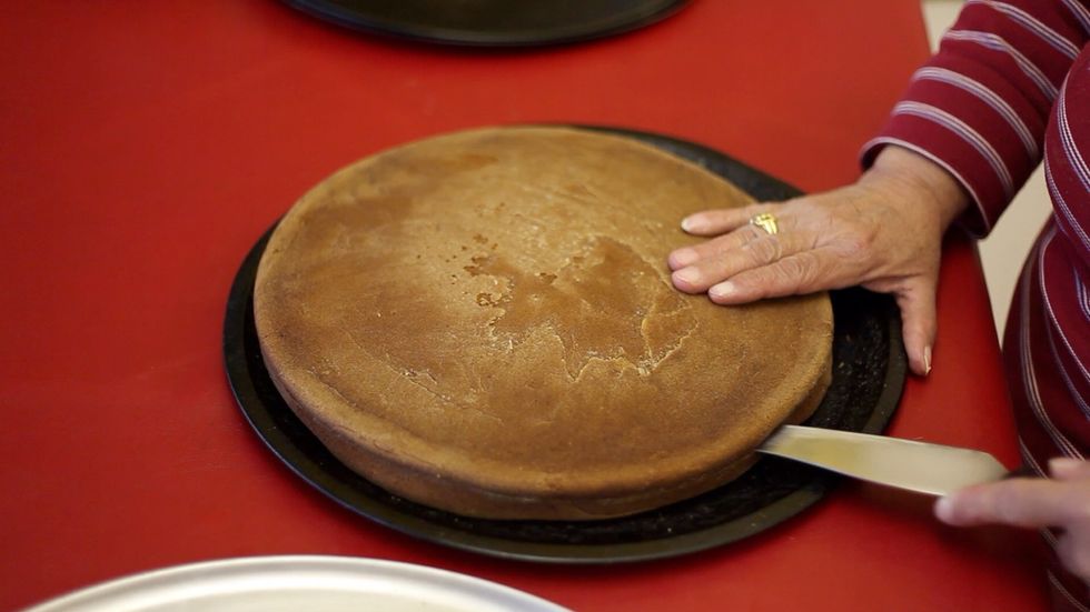 So once you're cakes are both ready, you need to cut them both in the centre and separate them. Best way is to cut a guide around the cake with a knife and then use a cotton string to divide the cakes