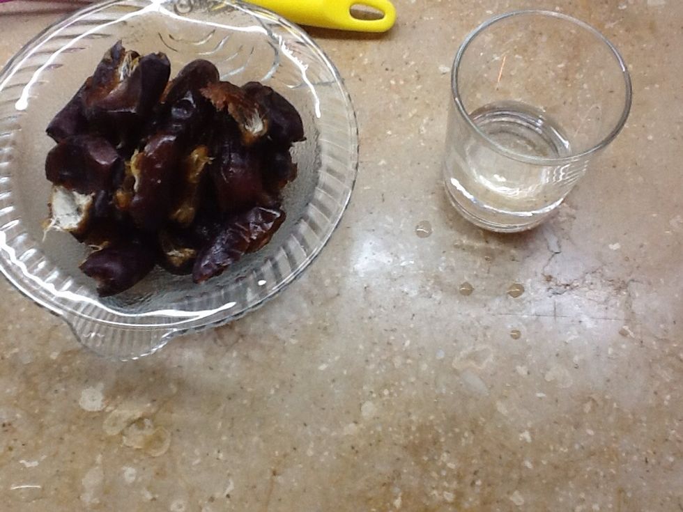 So the second step after dee-seeding the dates is to add some water over them and leave em for about 15mins to absorb as much water as they can , take a larger bowl and mash the water and dates :)