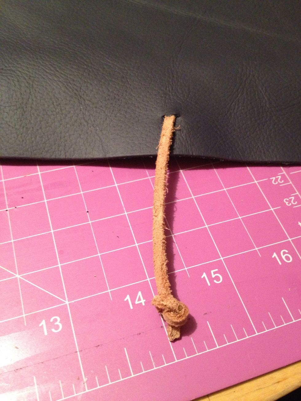 So to close my book I made the backside LP 3 inches longer so it wraps the pages. So I made a small slit in the centre and knotted a long piece of leather string to wrap around the book.