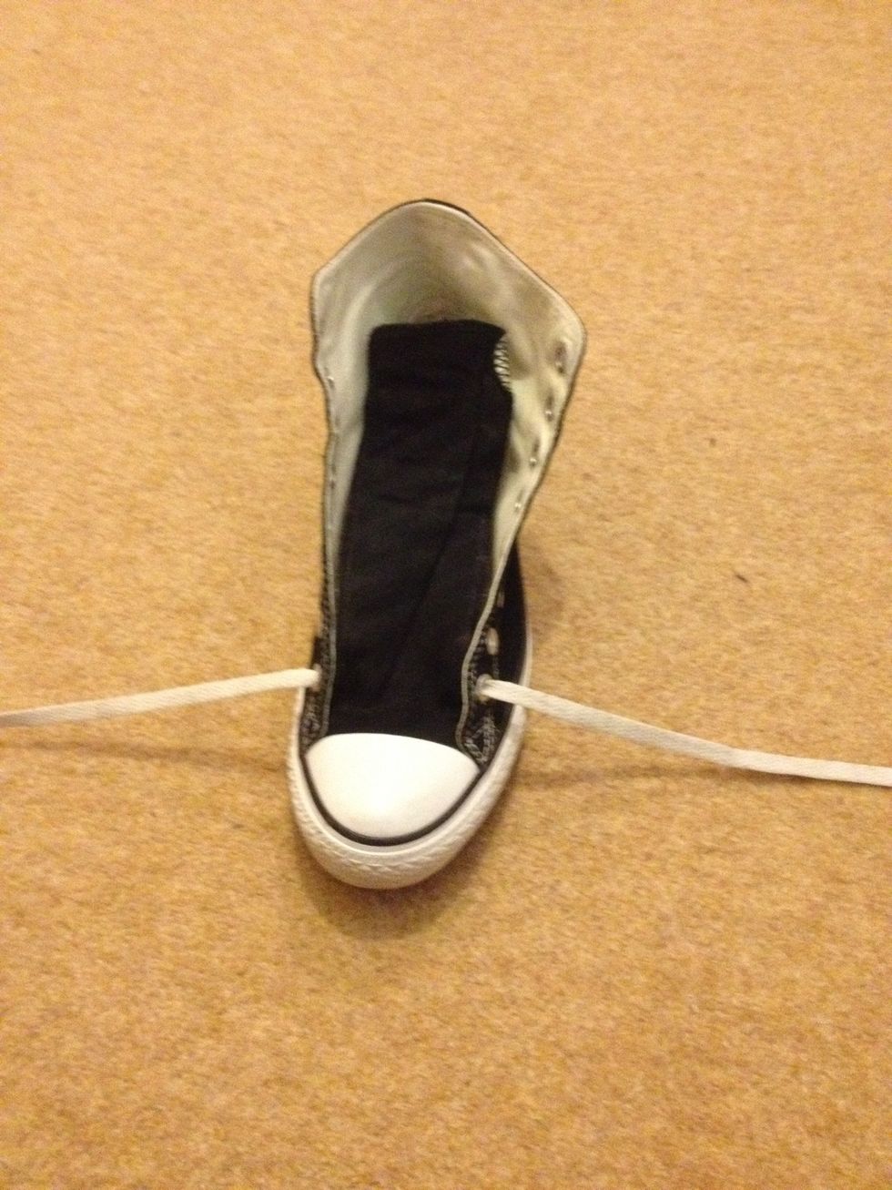 So we begin by breaking "converse law" (apparently) by lacing the bottom eyelets under rather then over the sneaker. I then lift the tongue over the lace to hide the bottom bar.