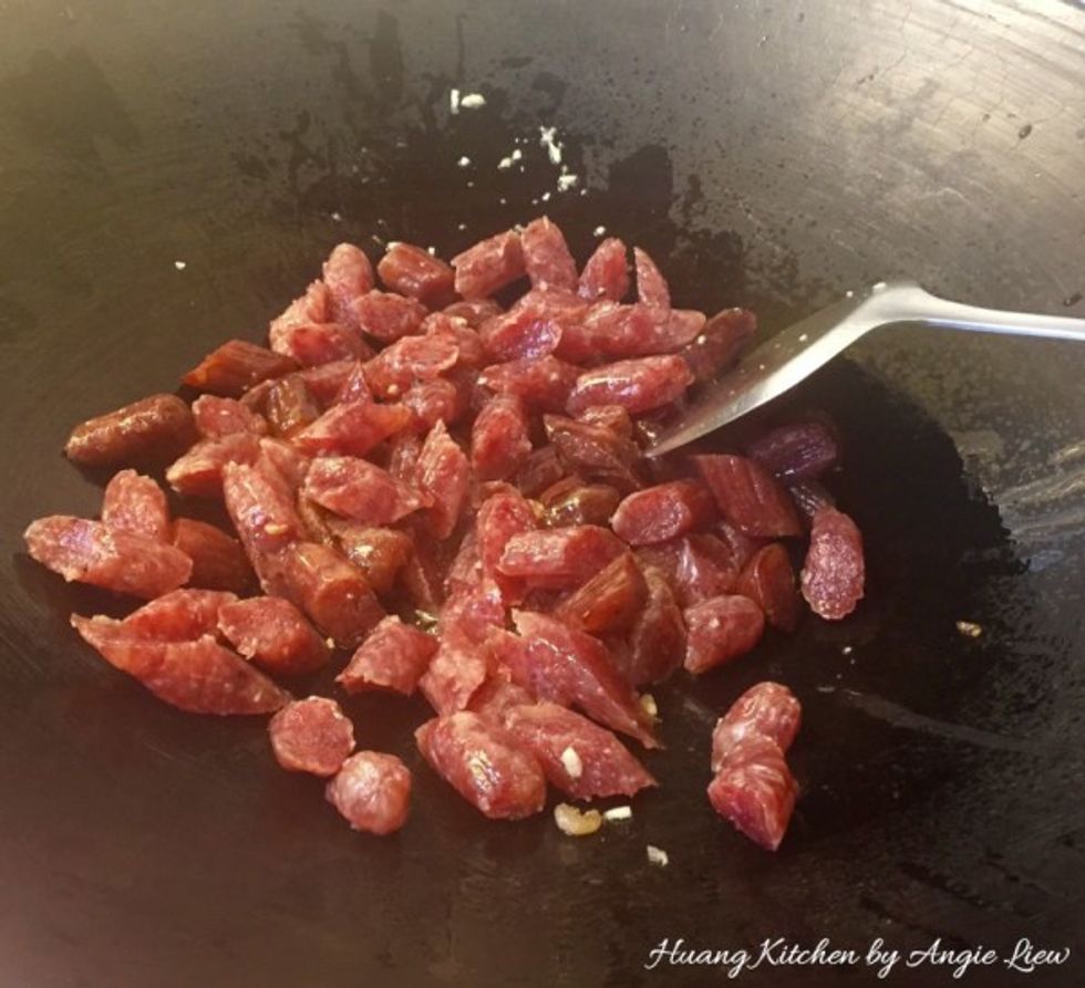 Soak chinese sausage in water for 15 minutes. Using scissors, cut to remove the skin surrounding the sausage and cut into thick pieces. Then briefly stir fry the cut chinese sausage and set aside.
